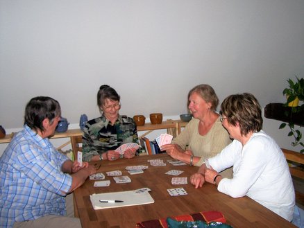 Lesestübchen zeigt Frauen an einem Tisch, die Karten spielen