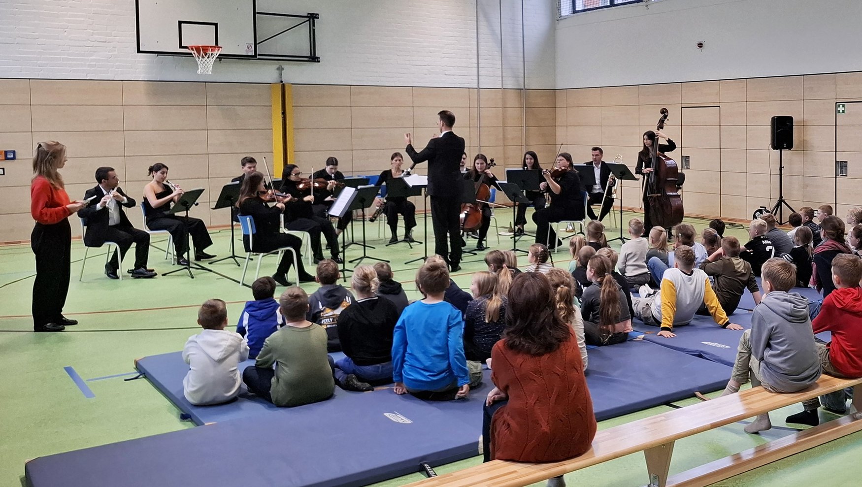 zeigt Ensemblegruppe während des Konzert sowie zuhörende Kinder und Erwachsene