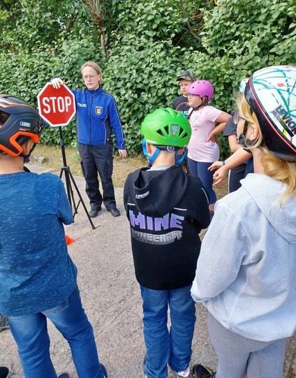 zeigt Kindergruppe mit Polizistin