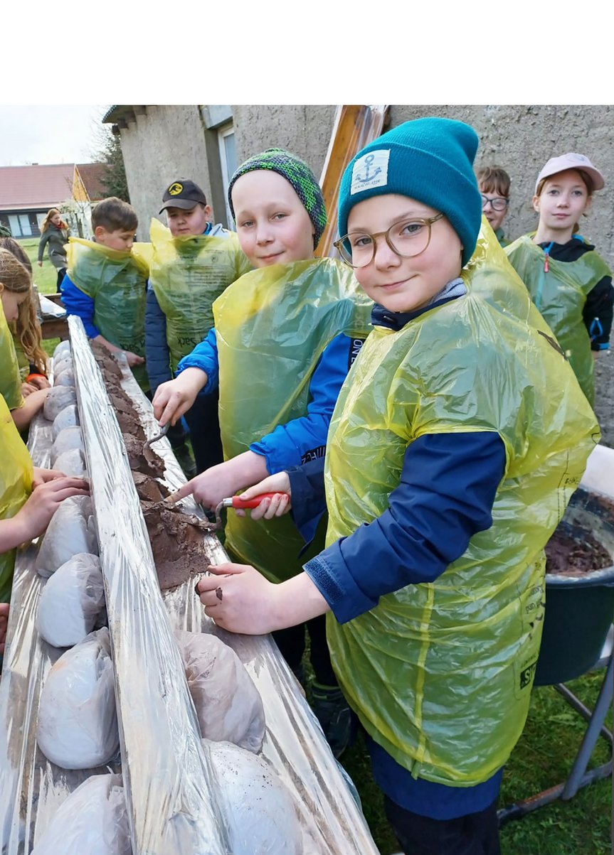 zeigt Kinder beim Bau von Schwalbennestern