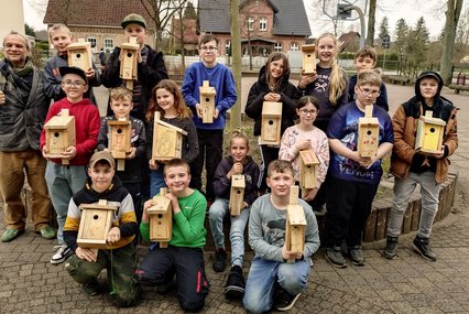 zeigt Kindergruppe mit ihren Vogelhäuschen