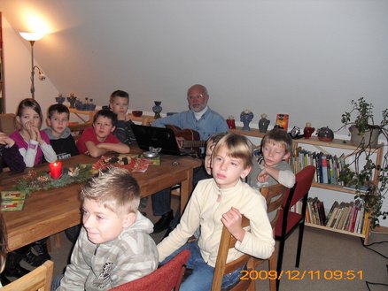 Lesestübchen zeigt Kinder an einem Tisch und einen Mann, der Gitarre spielt