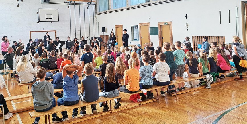 zeigt Musikaufführung in Turnhalle