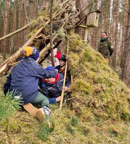 zeigt mehrere Kinder beim Bau einer kleinen Hütte