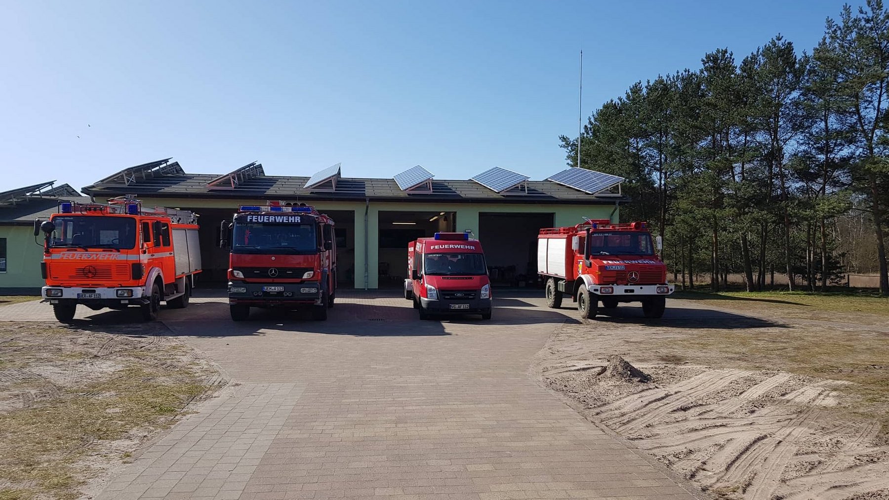 zeigt Feuerwehren vor Feuerwehrgebäude