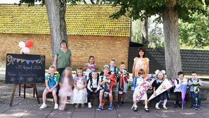 zeigt Gruppenbild der eingeschulten Kinder und Lehrerinnen