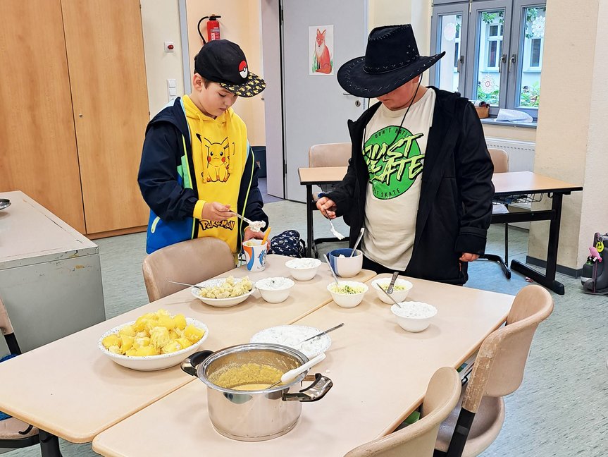 zeigt Schüler im Klassenraum bei Essenzubereitung
